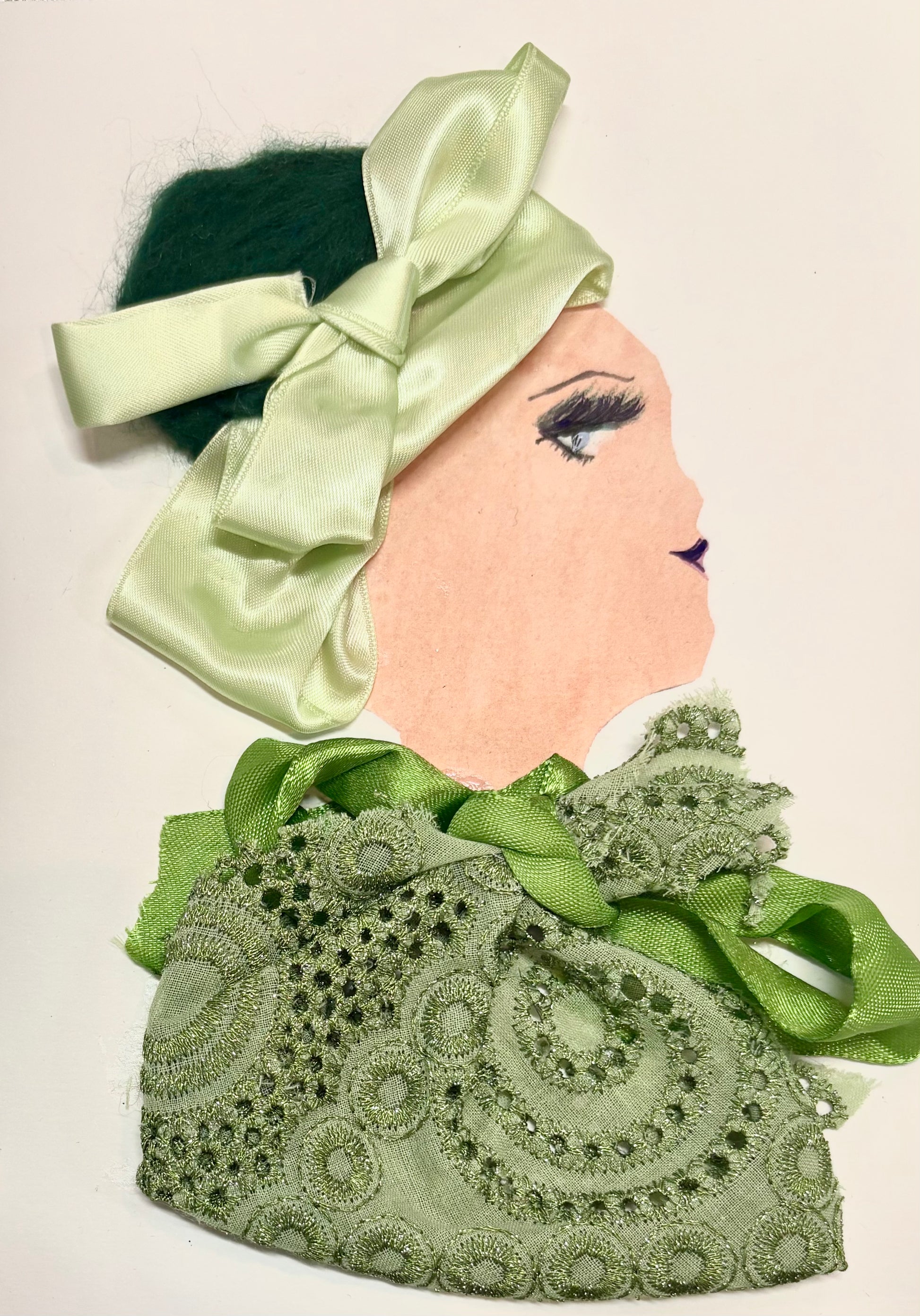 A woman wears a pale green headband and a green lace blouse. There is a grass green bow at the neckline of her blouse.