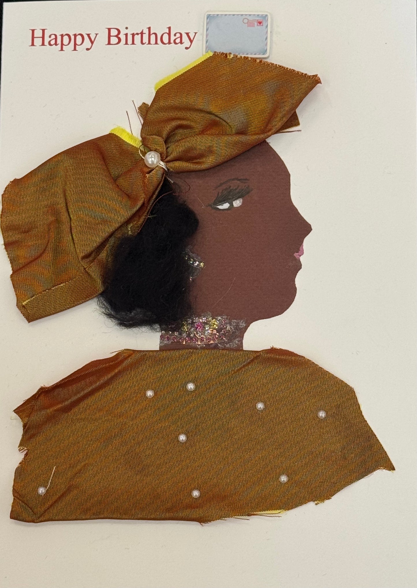 Handmade greeting card that can double as a piece of art featuring a profile of a woman with deep brown skin. She wears a large structured bronze-gold fabric bow on her head with a single pearl embellishment at its center. Her hair is short, black, and textured, visible beneath the bow. Her facial features include a sharply defined eye with long lashes and a white highlight, a subtle eyebrow, and small pink lips. She wears a small earring and a glittery choker-style necklace around her neck.