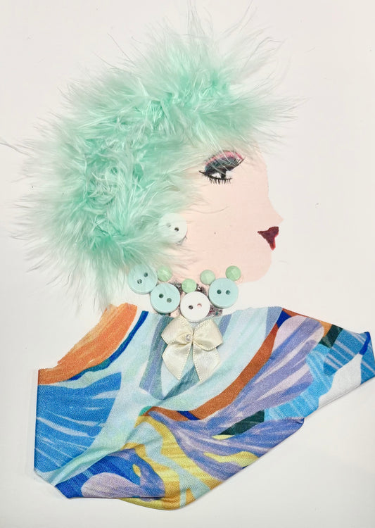 A woman has minty green hair. Her blouse has a swirl of colour with different blues, oranges, yellows, and purples. Her earring and necklace is made up of light blue buttons.