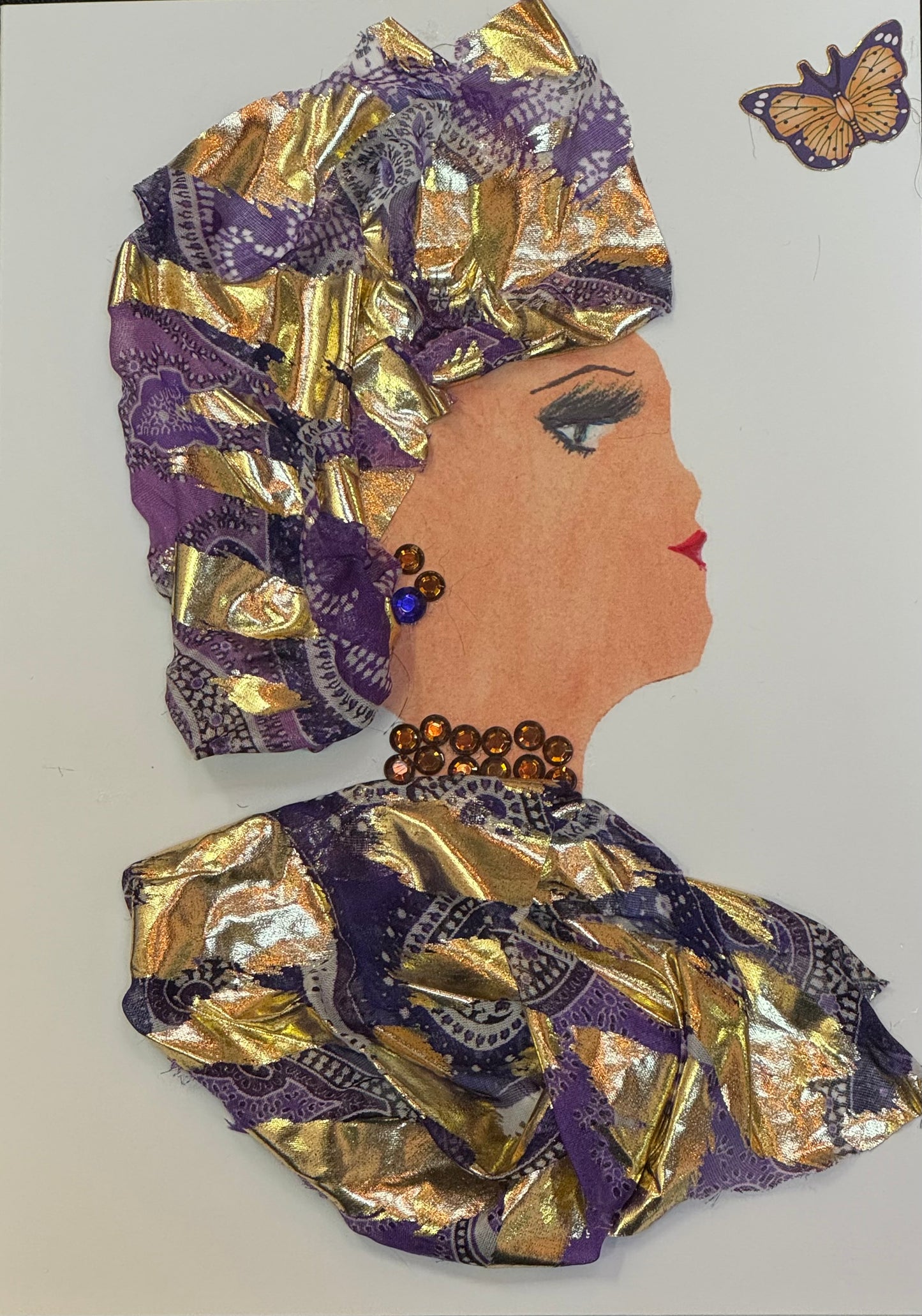 Handmade greeting card that can double as a piece of art featuring a side-profile of a woman wearing a gold and purple patterned headwrap and outfit, with jewel-toned earrings and necklace, and a small butterfly detail above her to the top right.