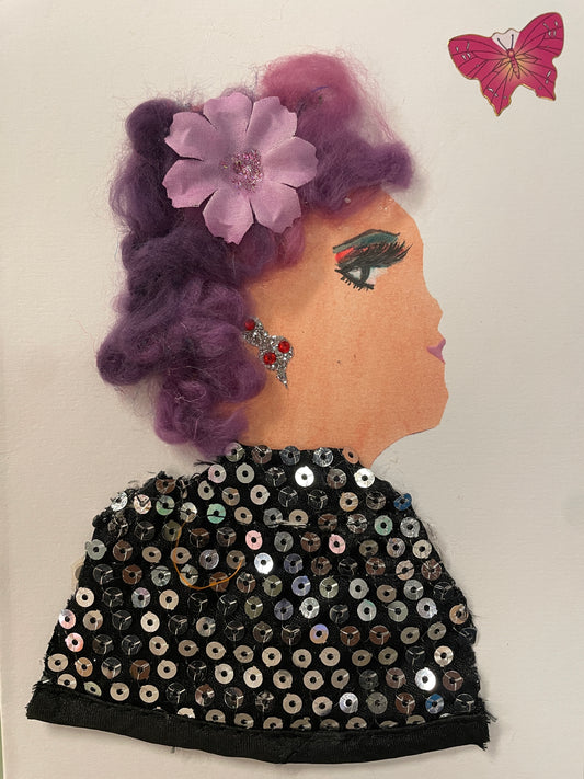 This is a handmade card of a woman named Dalston Depali. She has violet curly hair with a pink flower, wears a sparkly sequin cape, and there’s a pink butterfly sticker nearby.