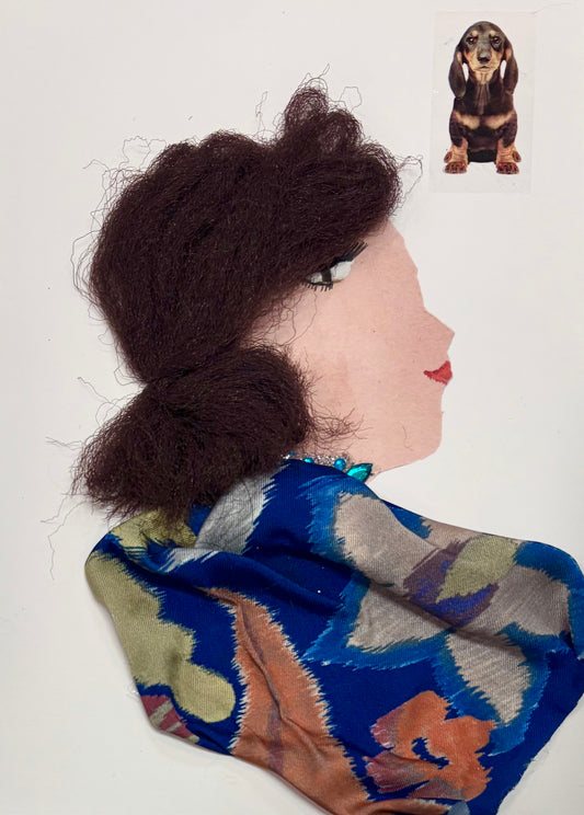 I handmade this card of a woman named Doctor Krista Kilburn. She’s shown in profile with fluffy textured brown hair, soft makeup, and a calm expression. She wears a vibrant blue patterned fabric with floral tones of green, orange, and grey, and a touch of turquoise beading at her neck. A sticker of a dachshund is placed nearby.