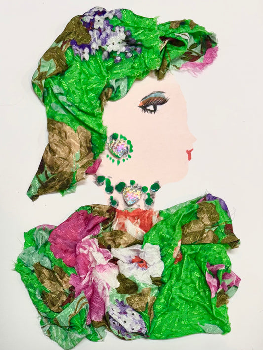 A woman wears a matching bright green hat and blouse with a floral pattern. The floral pattern has a mix of olive greens, purples, whites, and pinks. She has a multicoloured earring and necklace and wears green and orange eyeshadow.