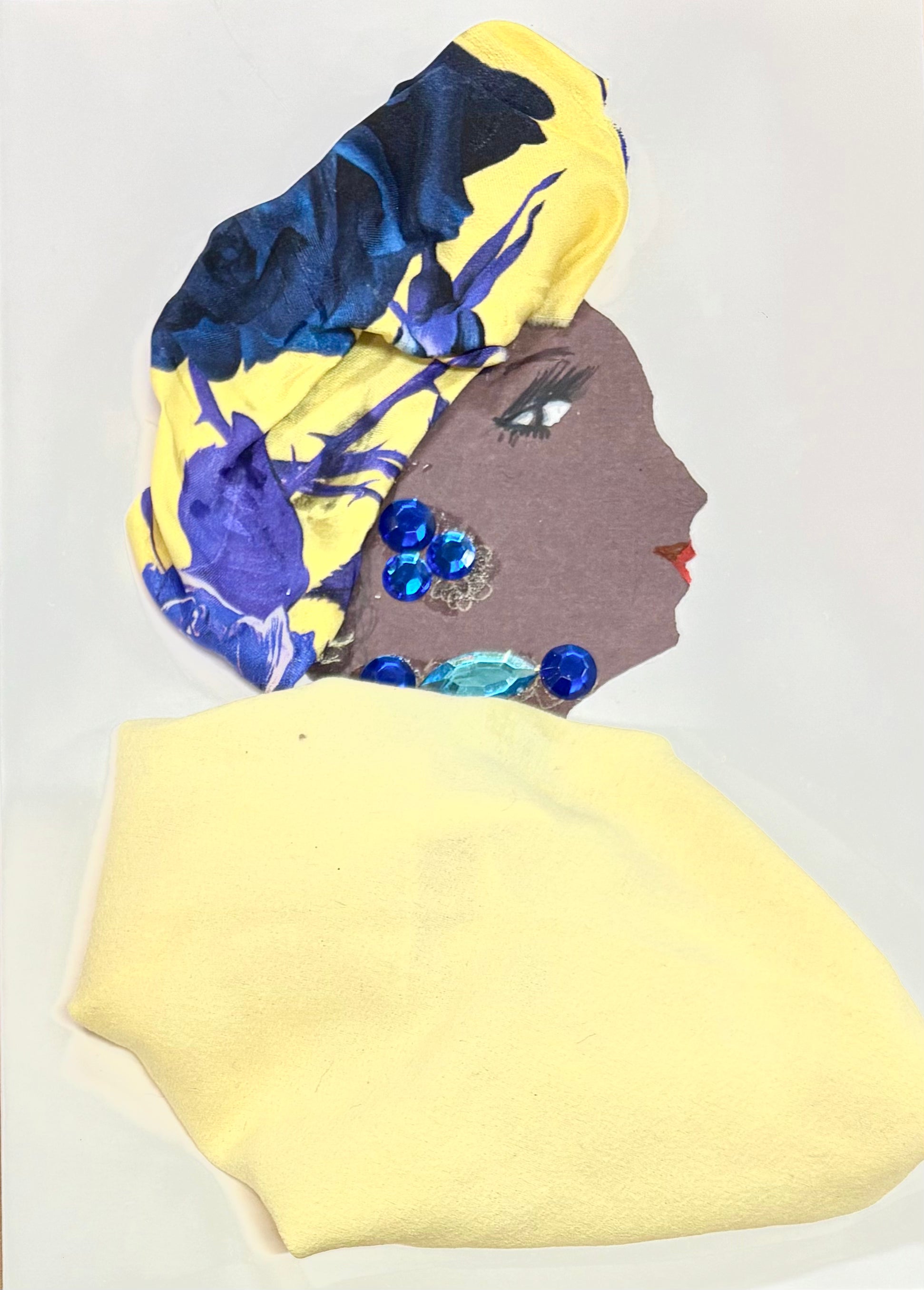 A handmade greeting card featuring a woman in profile, wearing a yellow and blue floral headwrap and a soft yellow outfit. She is adorned with shiny blue and turquoise gem decorations.