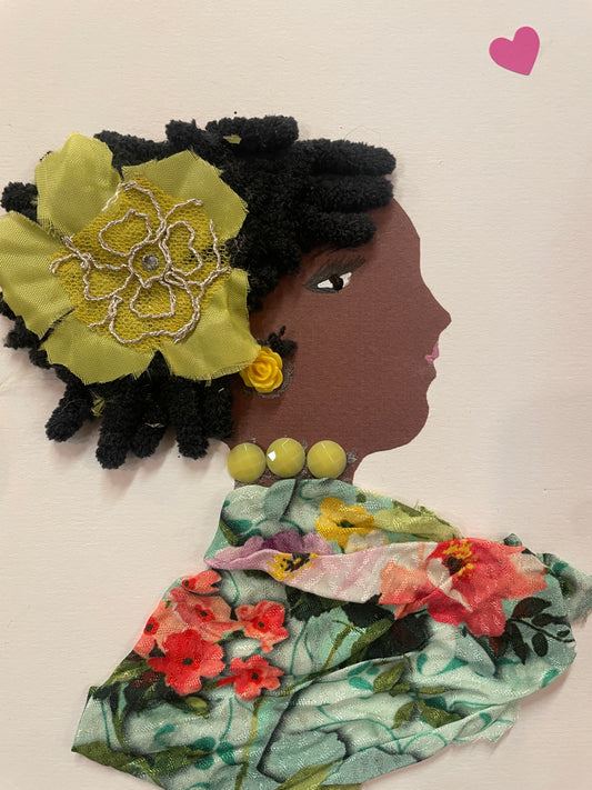 This is a handmade card of a woman named Flora Finchley. She has black textured hair with a yellow fabric flower, a rose-shaped yellow earring, and a floral dress. A small pink heart is in the top right corner.