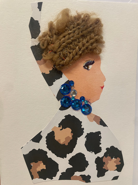 This is a handmade card of a woman named Giovanna Greatness, wearing a leopard-print outfit and head wrap with a brown braided hat, and large bright blue gem earrings and necklace.