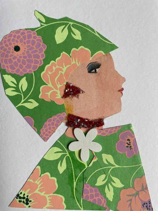 This is a handmade card of a woman named Hyde Park Poppy. She wears a matching hat and outfit made from green floral paper featuring bold pink, peach, and purple blooms. A red glitter earring and necklace add sparkle, and a white flower embellishment sits at the collar of her outfit.