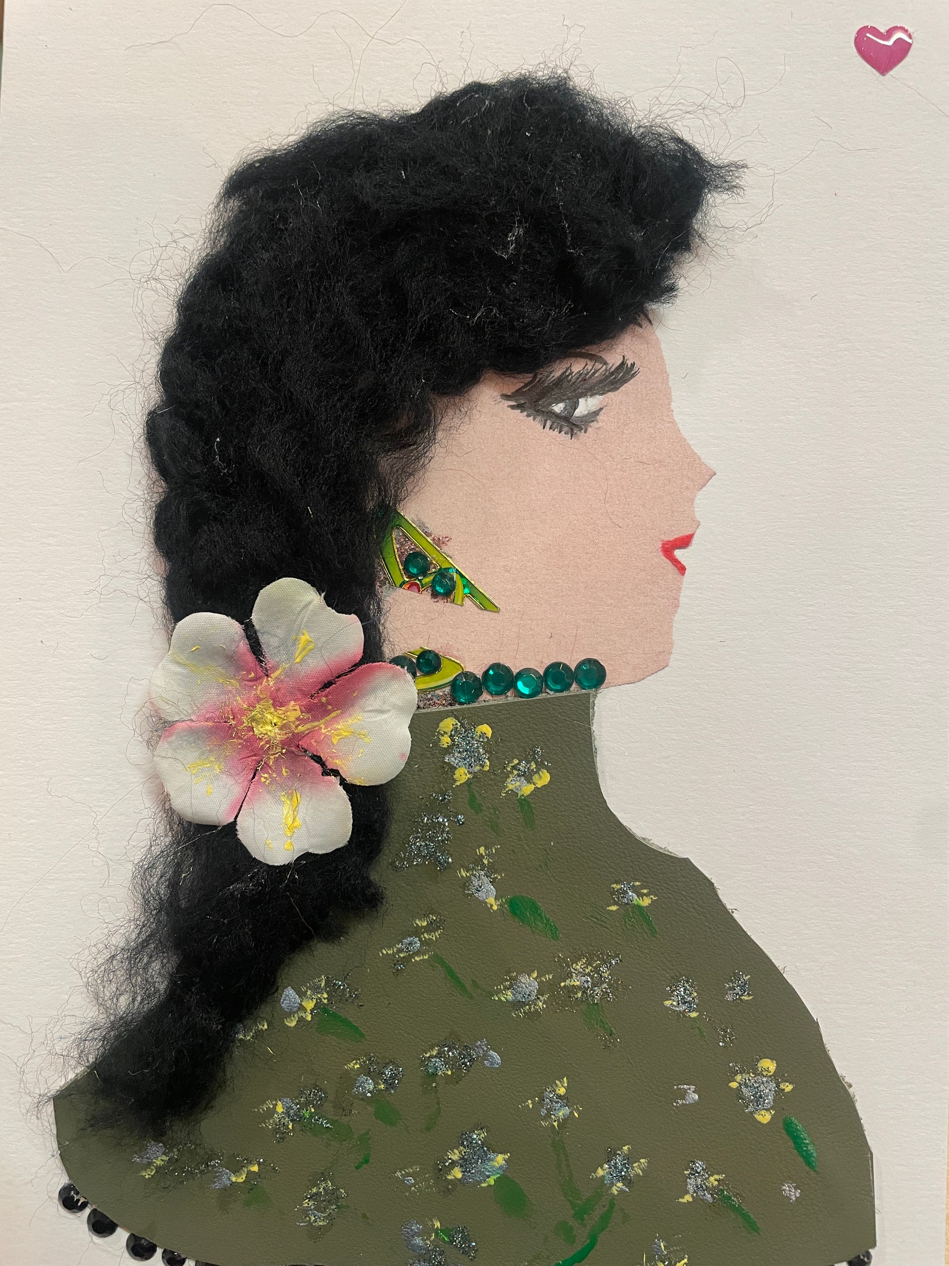 This is a handmade card of a woman named Laleah Limehouse. She wears a dark green blouse with painted flowers, has long braided hair with a white flower in it, and a small pink heart sticker in the top right corner.