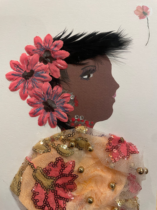 This is a handmade card of a woman named Orla Old Kent. She wears an orange and cream floral blouse, soft pink flowers in her straight black hair, and red jewellery. A flower sticker is in the top right corner.