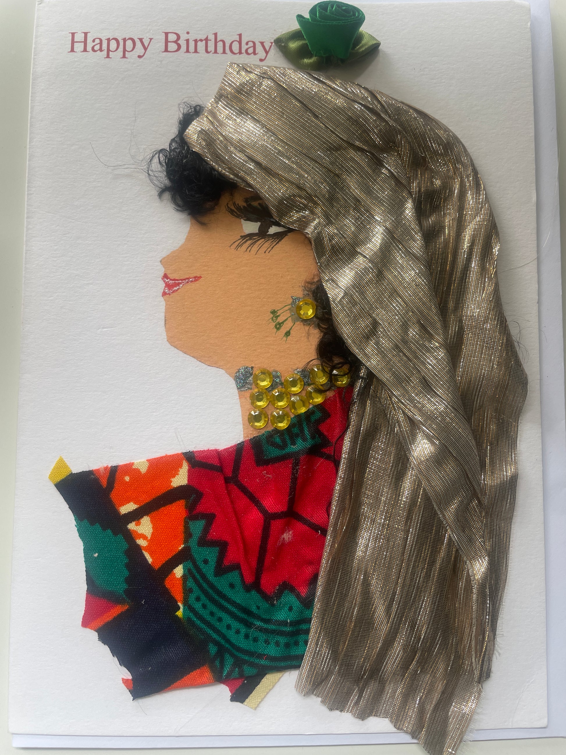 This is a handmade card of a woman named Zarina Zone One. She has a gold wrap, red and green patterned blouse, curly black hair, yellow gems, and a green ribbon flower with 'Happy Birthday' text in the background.