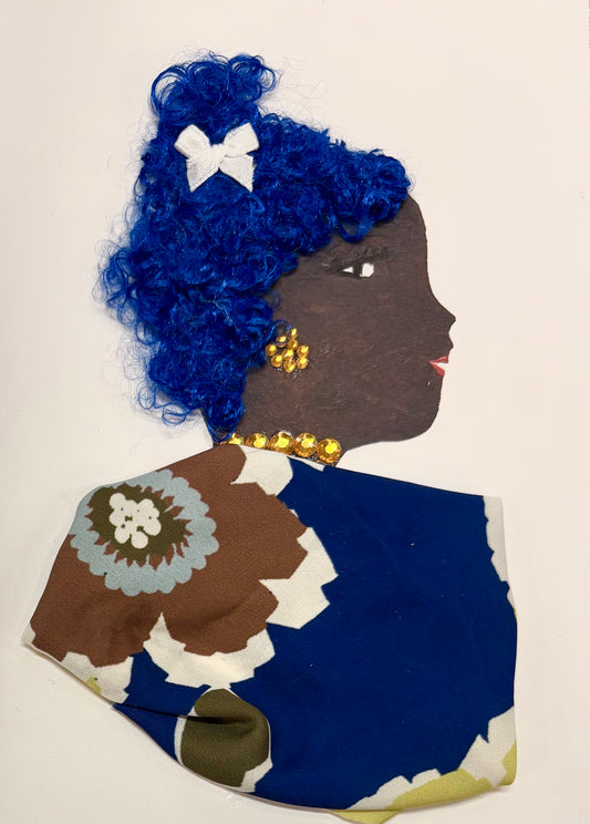 A side profile of a woman made with craft materials. She has curly blue hair styled with a small white bow. Her gold beaded earrings and necklace add sparkle. She wears a colorful outfit made from fabric with bold floral patterns in brown, blue, and white. Her eye and lips are drawn on.