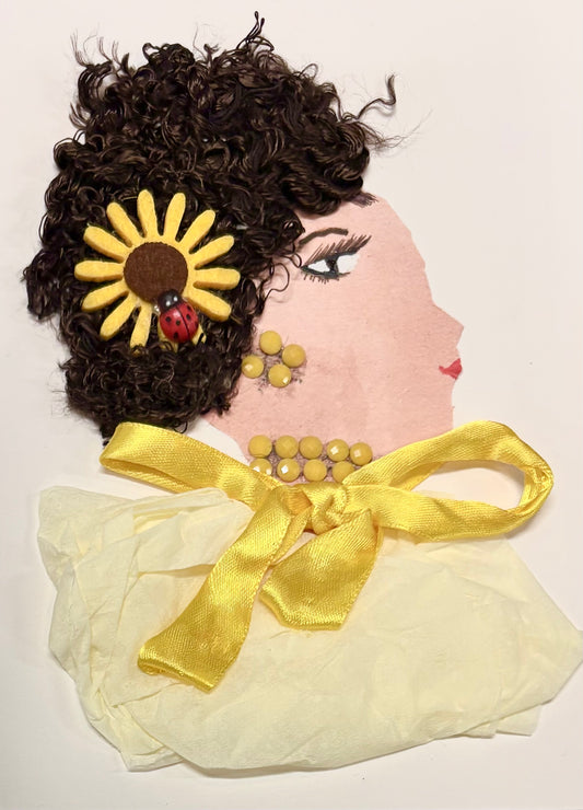 I handmade this card of a woman named Lady Canary. Her curly hair is decorated with a bright yellow flower and a tiny red ladybird. She wears matching yellow earrings and a necklace, and her outfit is made from soft yellow fabric tied with a satin ribbon.
