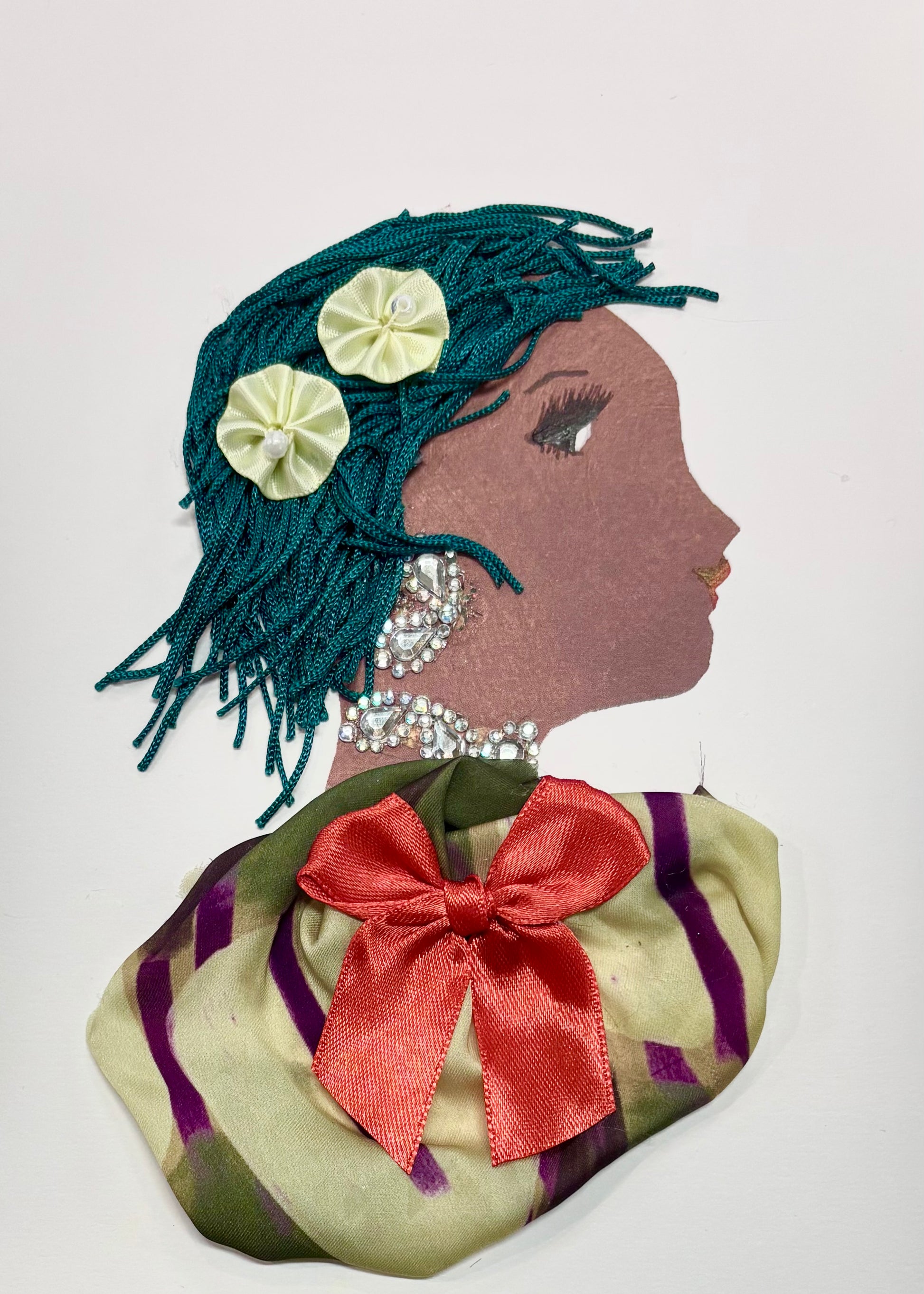 A woman has emerald green hair and two pastel green flowers as an accessory. Her blouse is an olive green with purple accents. A coral bow is centered on her blouse. She wears a silver earring and necklace.