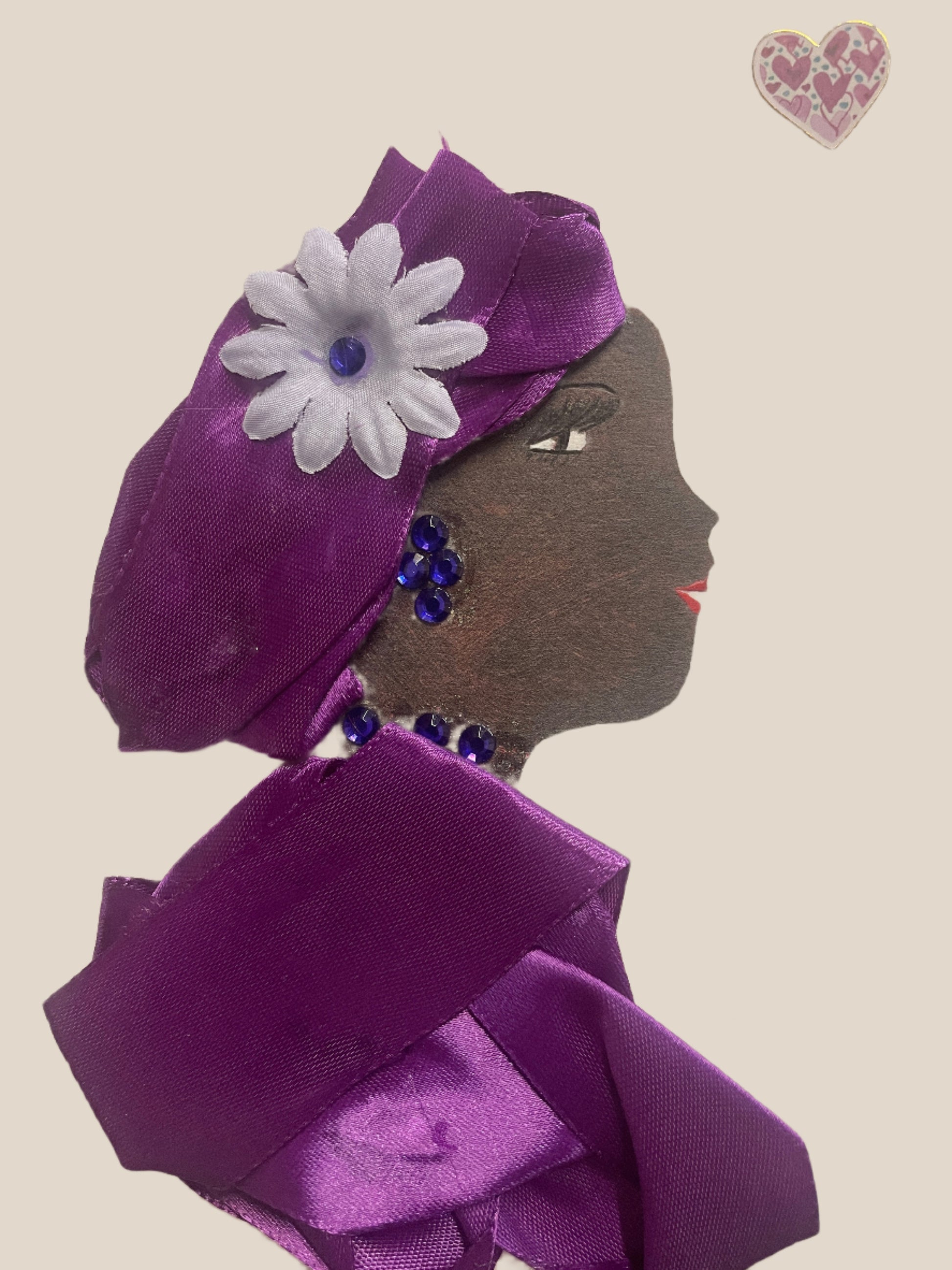 This is a handmade card of a woman named Leilani Lavender. She wears a shiny purple wrap with a white flower in her hair and a purple gemstone necklace. A heart sticker is in the top right corner.
