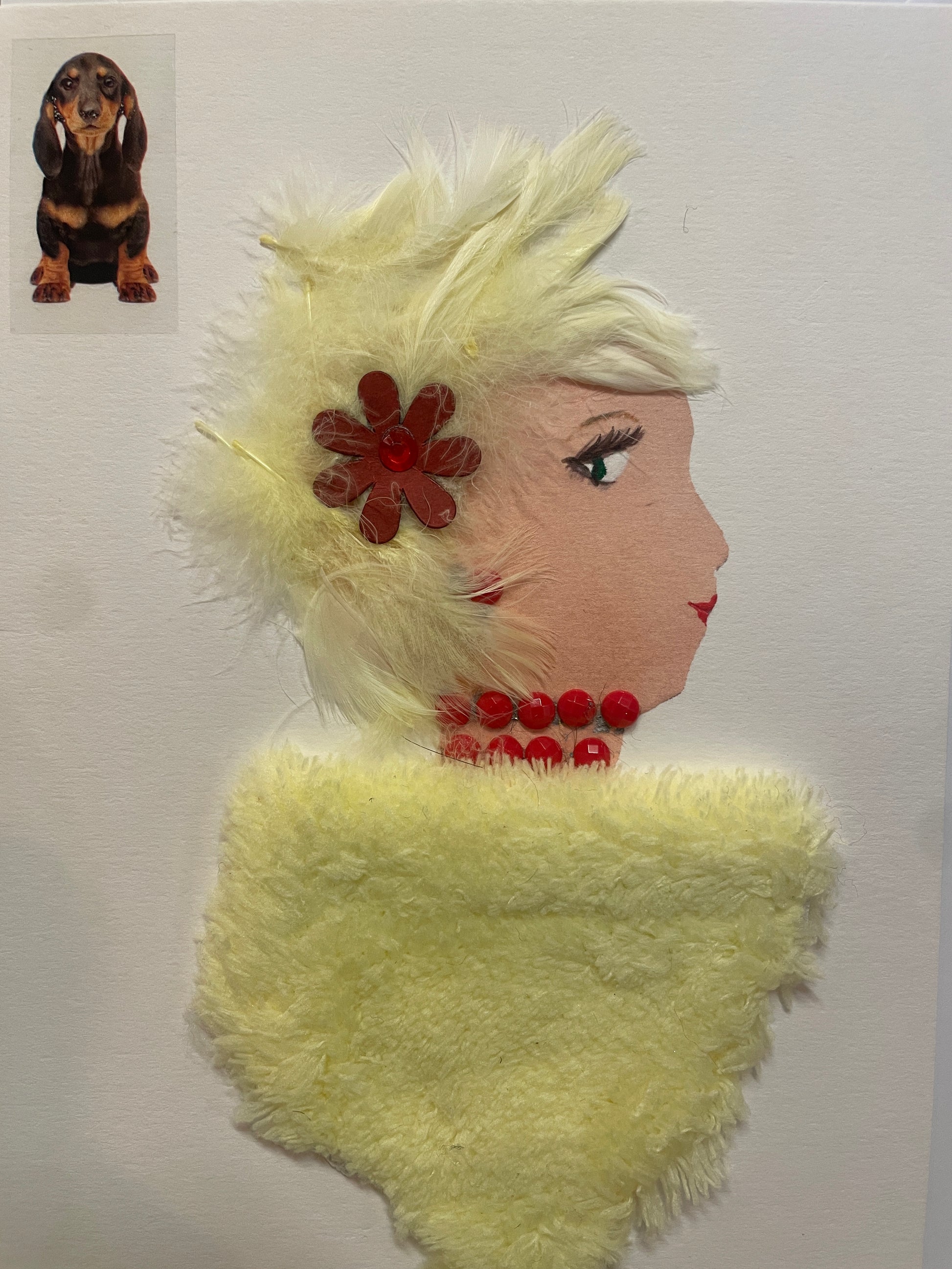 This is a handmade card of a woman named Lemon Lane Layla, with fluffy yellow hair decorated with a red flower, a soft fuzzy yellow garment, and a necklace made of shiny red beads. A adorable dog  is found in the top left corner.