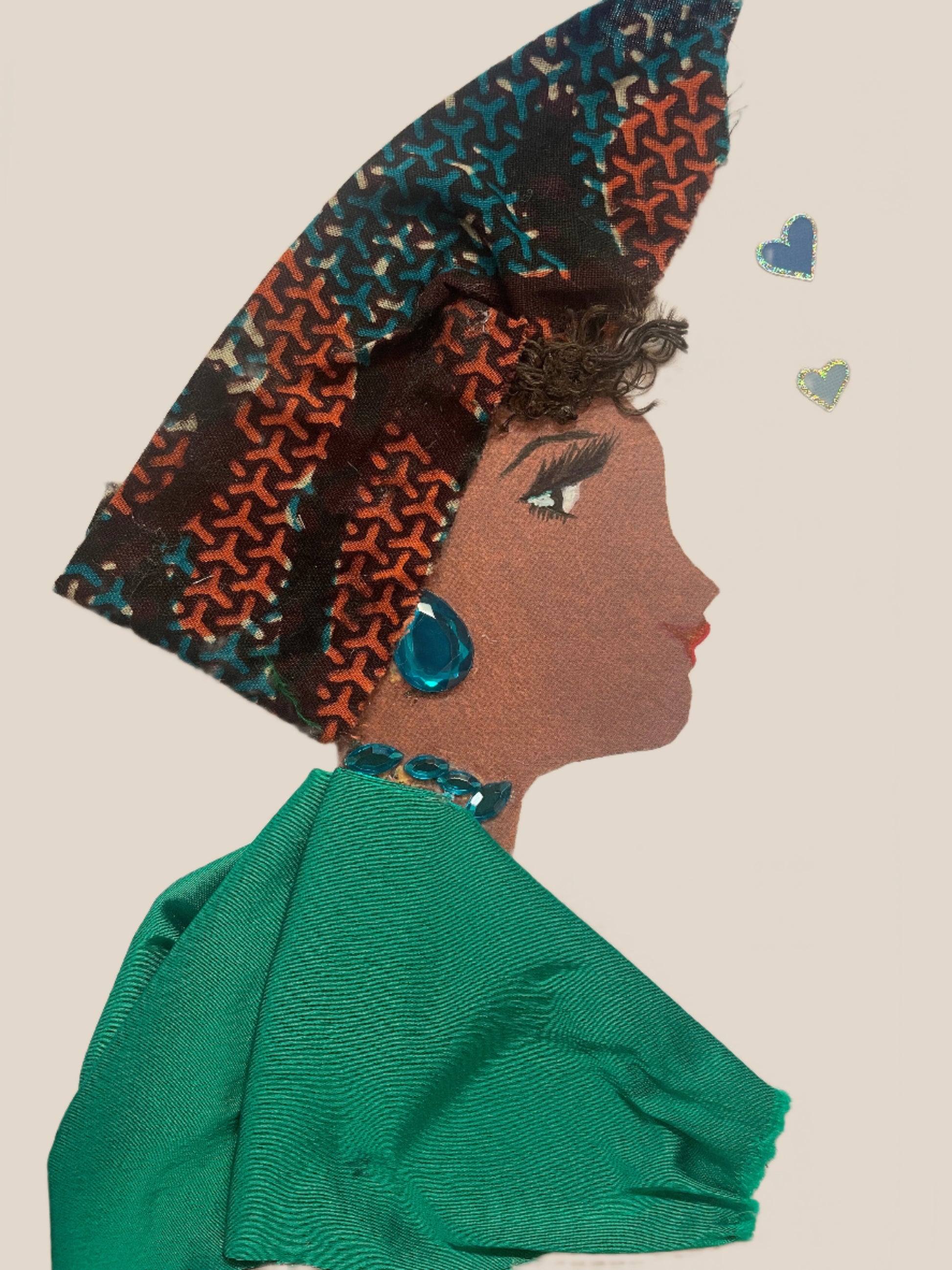 This is a handmade card of a woman named Lianne Loftus. She wears a tall wrap with black, red and blue patterns, blue gemstone earrings and necklace, and a flowing green outfit.