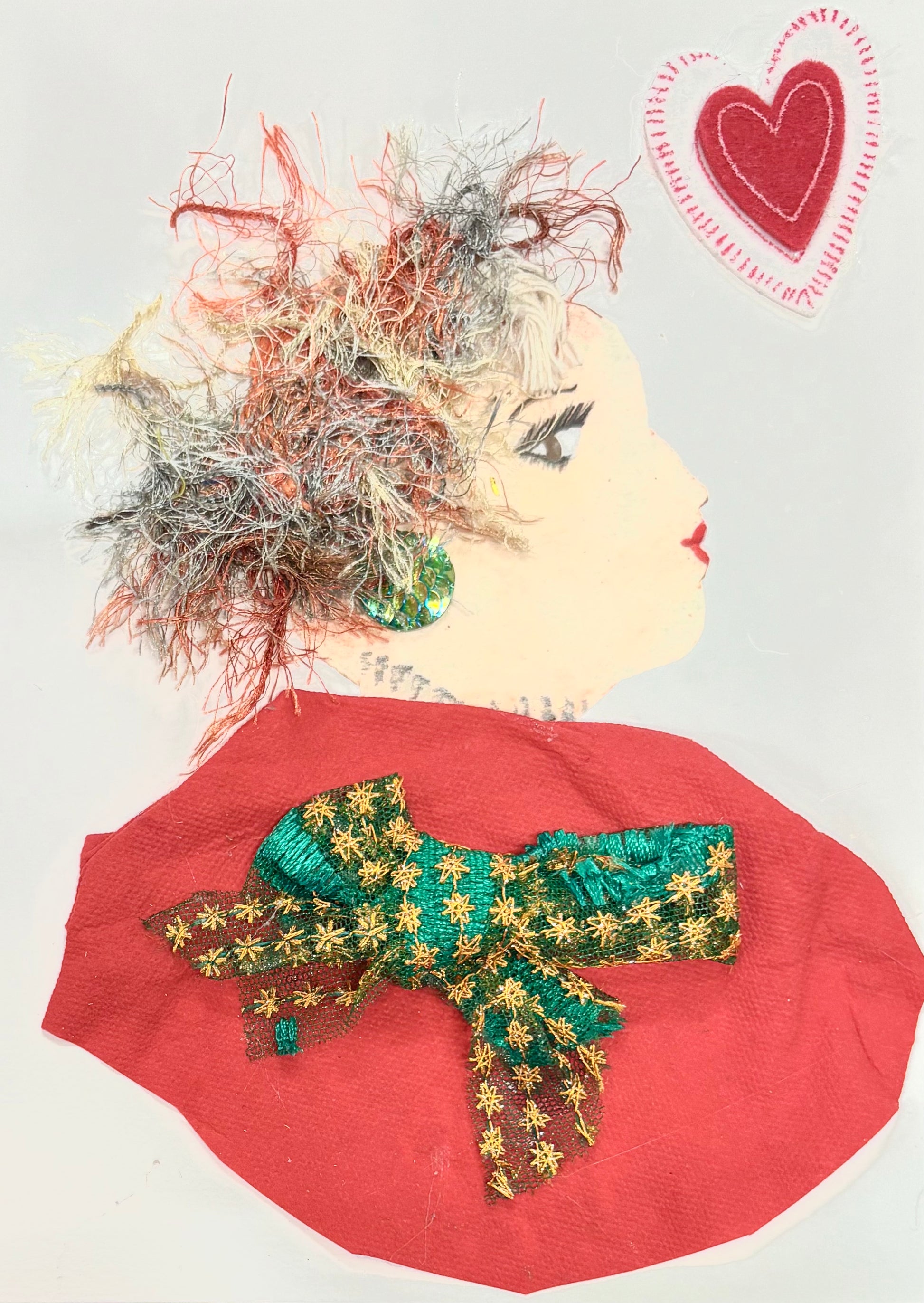 This is a handmade card of a woman named London Bridge Lady. Her textured, multi-colored hair has a playful, windswept energy, and she's dressed in a bold red with a festive green and gold bow. A soft heart detail adds a gentle, affectionate touch.