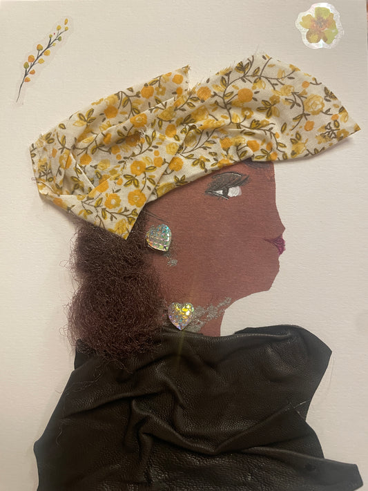 This is a handmade card of a woman named Marissa Mayfair. She wears a yellow floral head wrap and a flowing black outfit with curly hair and gem heart earrings. Two flower stickers decorate the background.