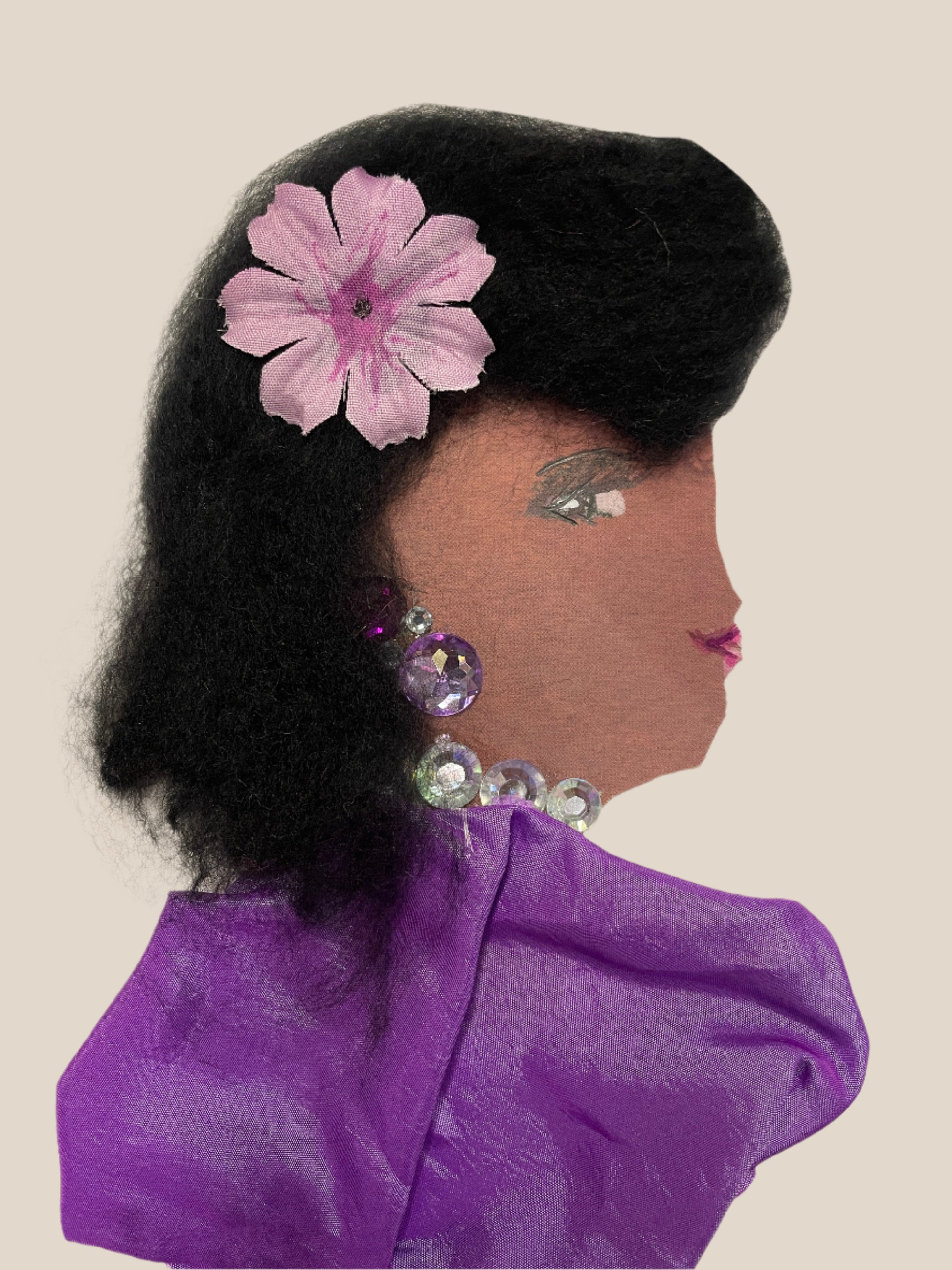 Handmade card showing a woman in profile with voluminous black hair, a pink flower accessory, and large iridescent gem earrings and necklace. She wears a shiny purple dress.