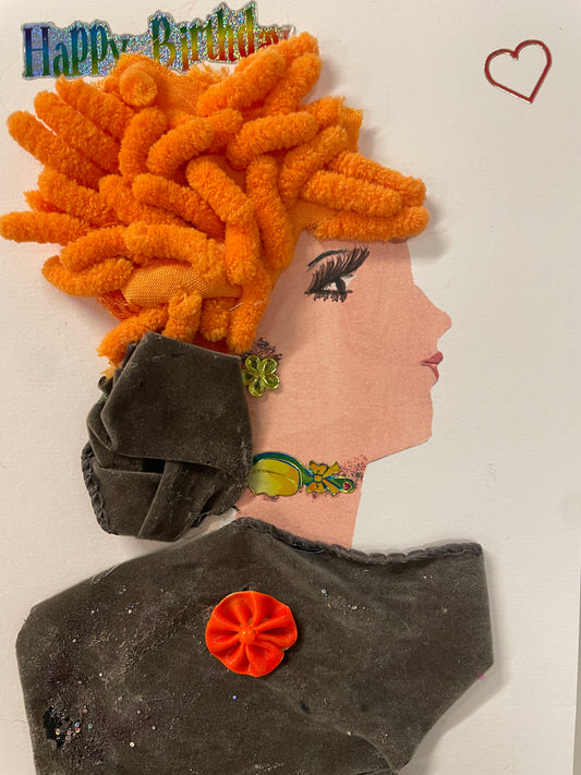 This is a handmade card of a woman named Mavis Bright with vivid orange curly hair, a green earring, and a fuzzy grey velvet dress, with a "Happy Birthday" sticker and a heart above.