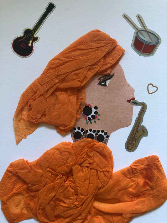 I handmade this card of a woman named Orange SAXOPHONE. She’s shown in profile with expressive eyes, red lips, and layered orange fabric wrapping her hair and outfit. Her bold black-and-white jewellery is accented with small teal dots. A gold saxophone sticker appears by her mouth as if she’s playing, with a floating heart nearby. Around her are playful stickers of a guitar and drum, adding to her lively, musical vibe.