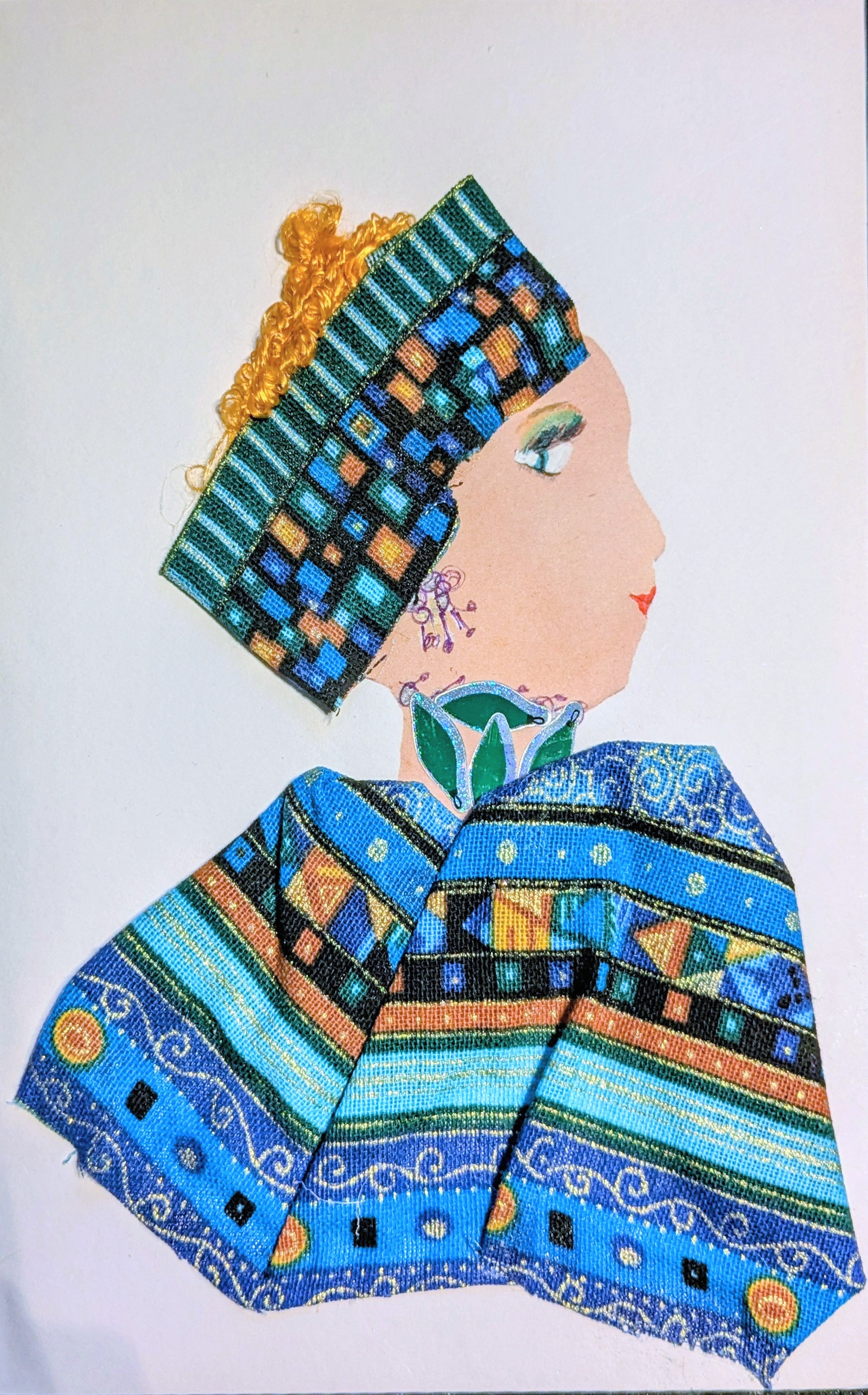 A side profile of a woman made with mixed media. She has curly yellow hair partially covered by a colorful patterned headwrap in shades of blue, green, and orange. Her earrings and necklace are drawn in purple and green. She wears a matching fabric top with bold geometric and swirly designs. Her eye and lips are drawn on.