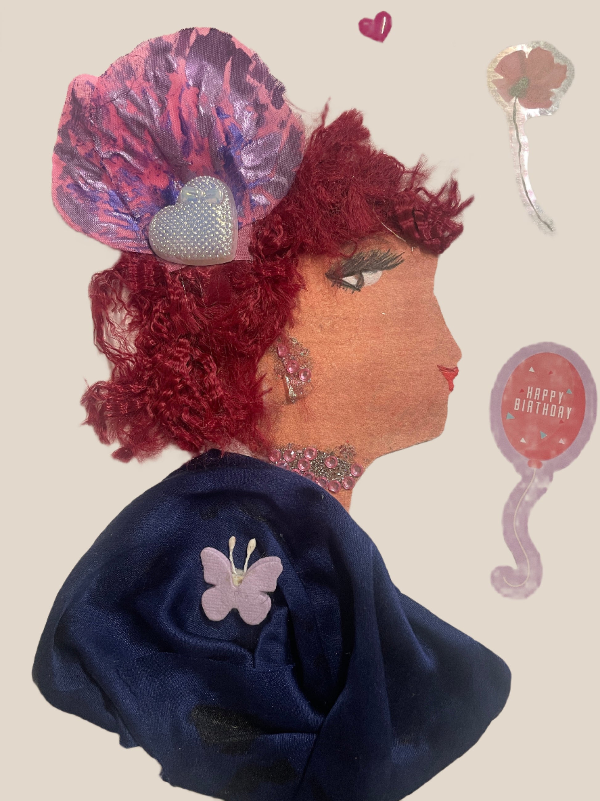 This is a handmade card of a woman named Princess Ruby Rosehill. She has red textured hair, a pink flower accessory with a silver heart, and wears a navy wrap with a purple butterfly. Heart and birthday stickers are in the background.