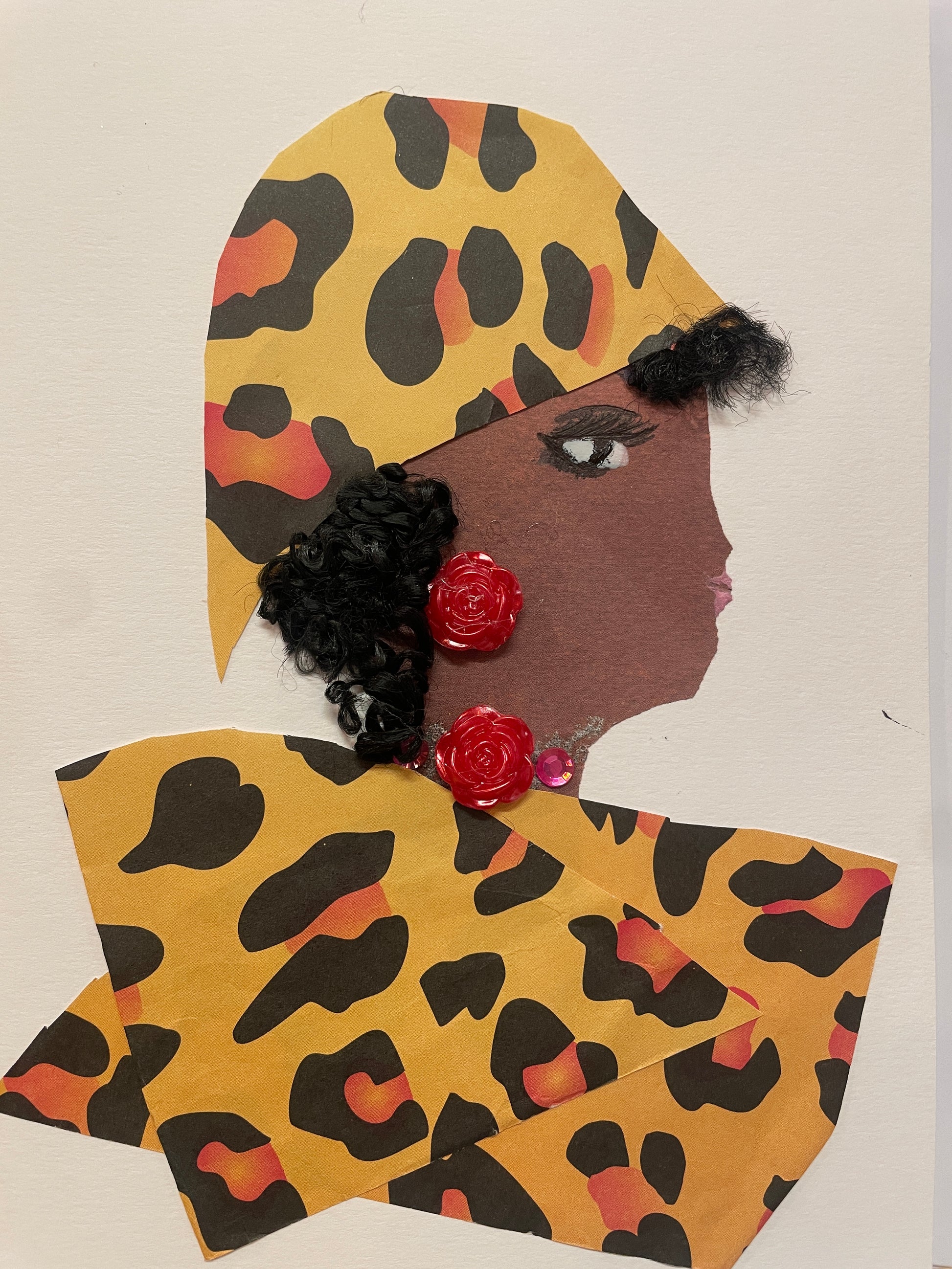 A handmade card of a woman named Rea Richmond in profile wearing a golden-yellow animal print wrap and red flower-shaped earrings. Her outfit matches her headwrap.
