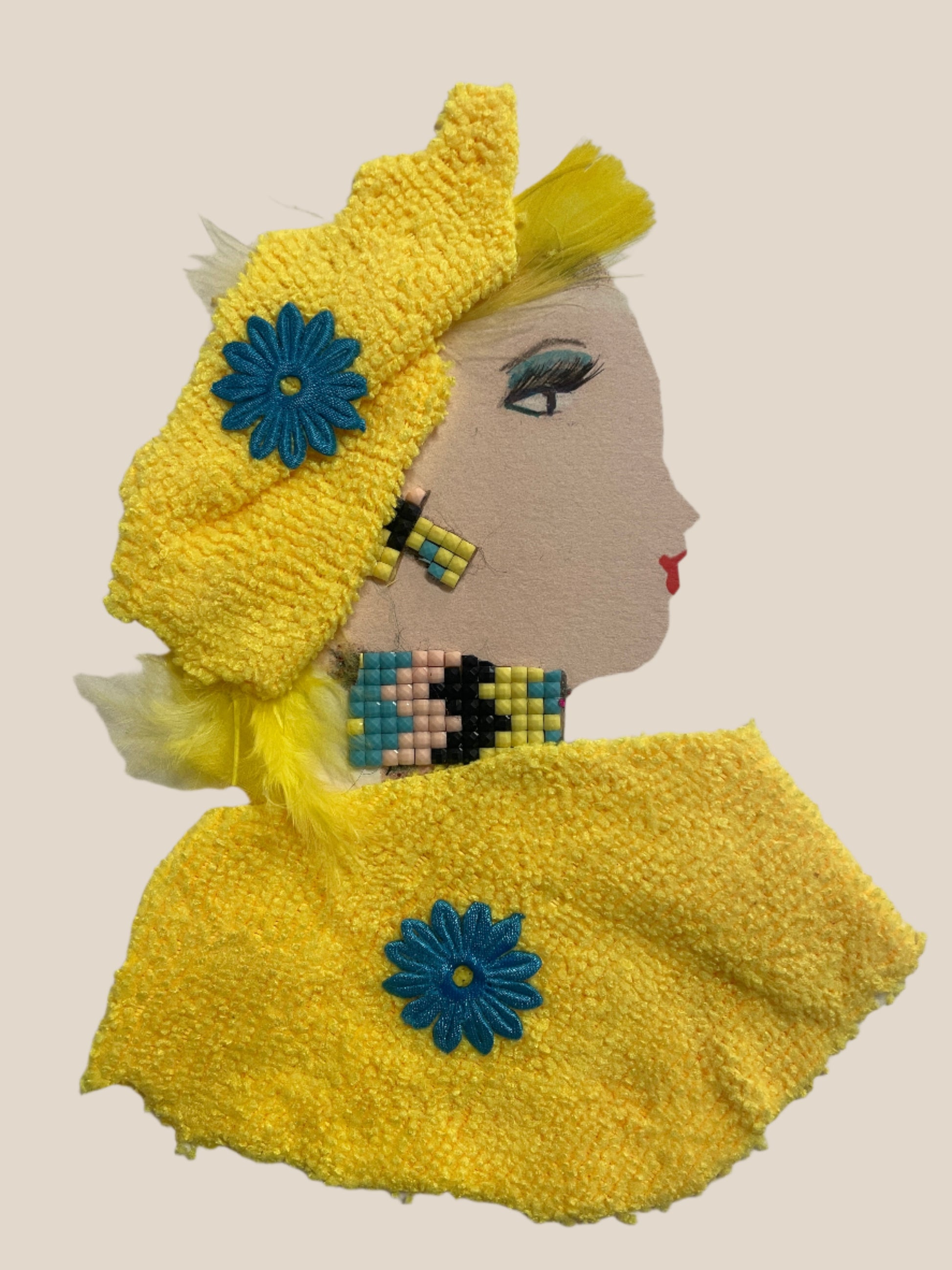 This is a handmade card of a woman named Sunny Shoreditch. She wears a yellow textured outfit with a matching beret-style hat and blue flower embellishments. Her hair peeks out from underneath, and her necklace is made of colourful square beads.