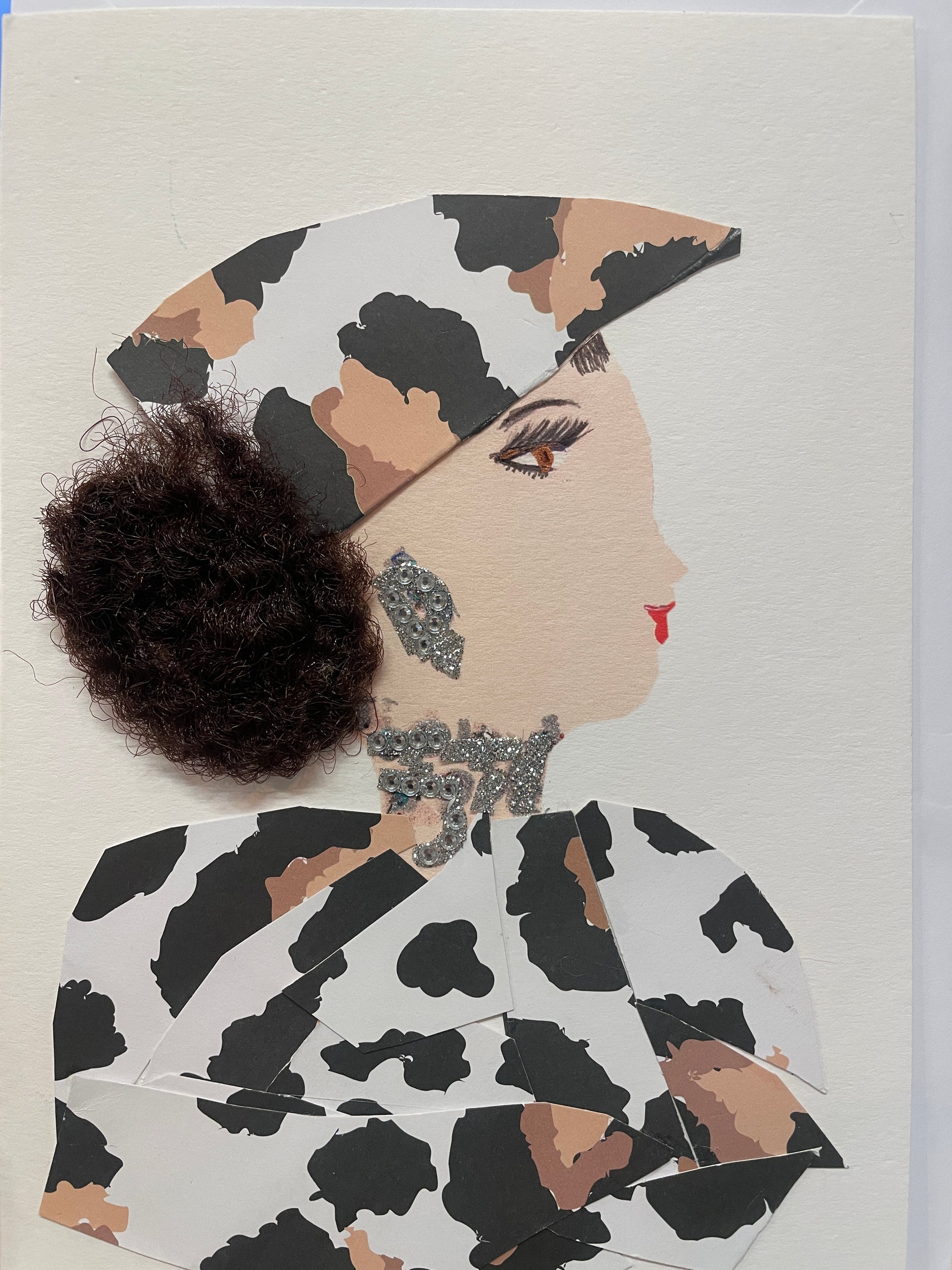 This is a handmade card of a woman named Tottenham Teah, wearing a layered black and white outfit, a high coiled bun, silver earrings, and a decorative silver necklace.