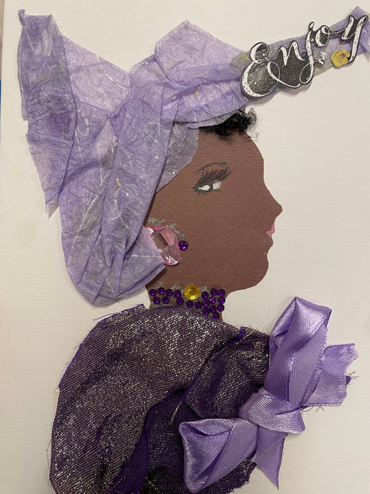 Handmade card of a woman in profile wearing a lavender headwrap with silver flecks, sparkling earrings, and a purple jeweled necklace. Her dress is made of shimmery violet fabric with a satin bow. A small “Enjoy” sticker decorates the top corner.