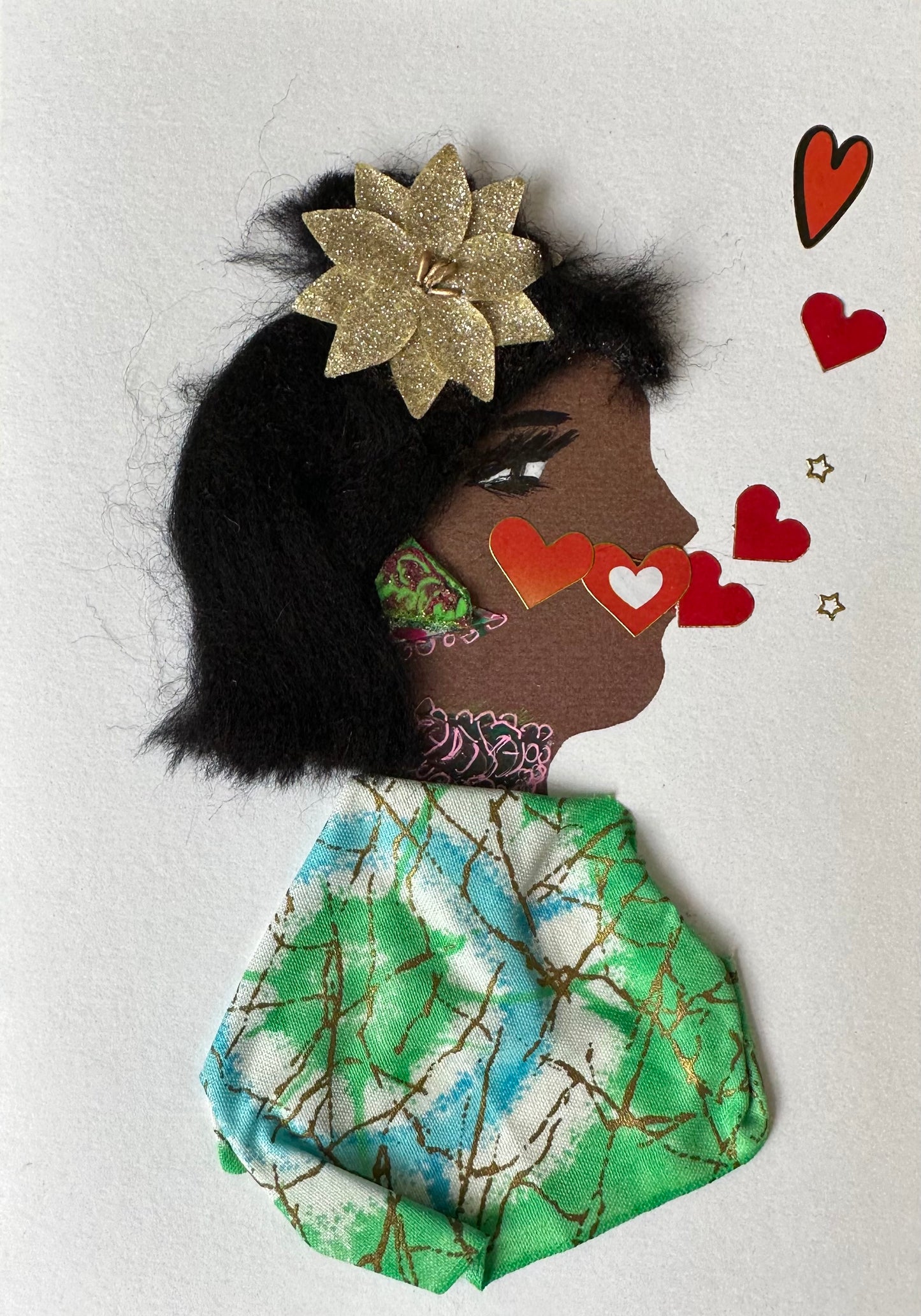 Kemi Kenton is wearing a green dress with multi-colour patterns. There are red and pink hearts coming out of her mouth up the card.