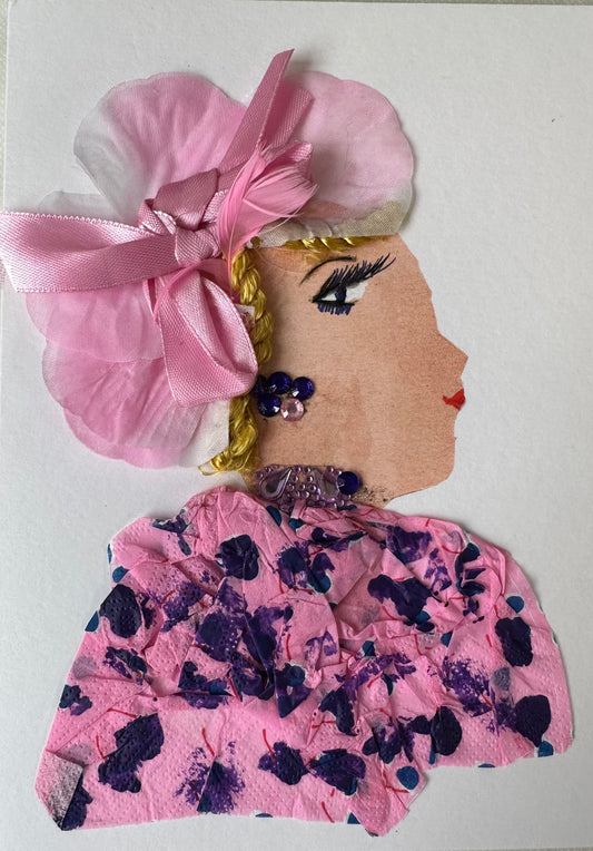 This handmade card of Kensington Kathy illustrates a woman in a pink and blue blouse. She has a hair piece with a pink bow and flower pieces. The outfit is completed with purple and pink gemstone earrings.