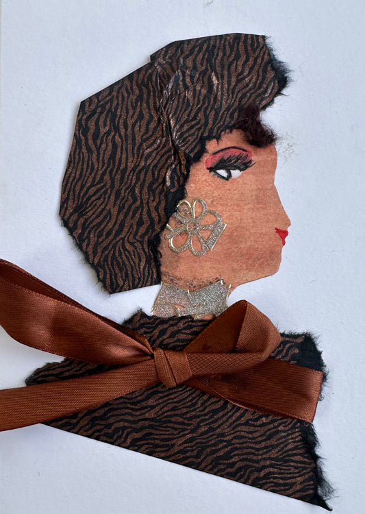 I designed this handmade card of a woman dressed in a brown and black tiger print blouse and hatinator. Her blouse is held together with a chocolate brown ribbon. Her earring is a silver flower which matches her silver necklace.