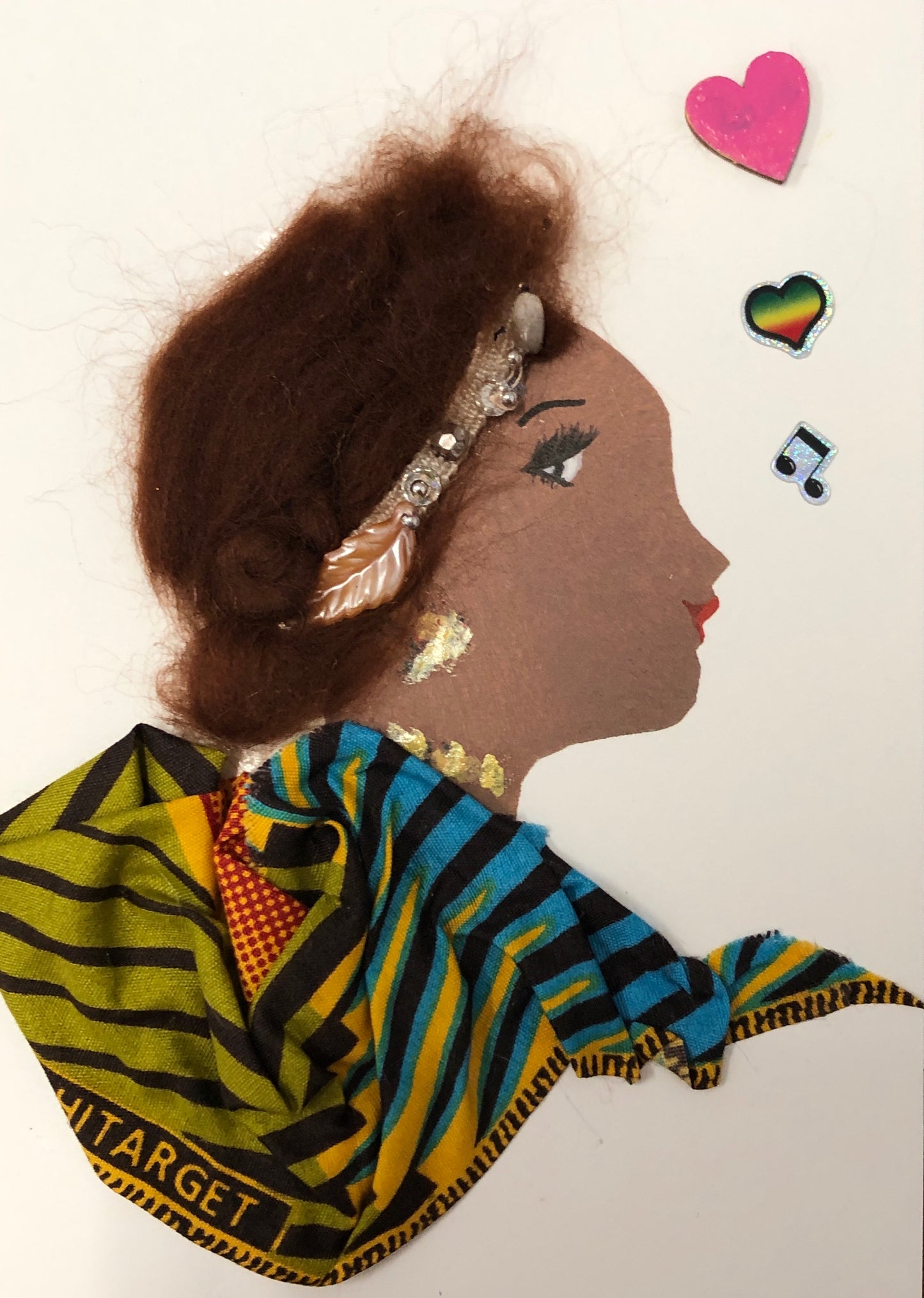 This card has been given the name peaceful pat. She wears a green, blue, yellow and black printed blouse, has short brown hair which has a headband in it, and in the righthand side, there is a pink heart, rainbow heart, and music note.