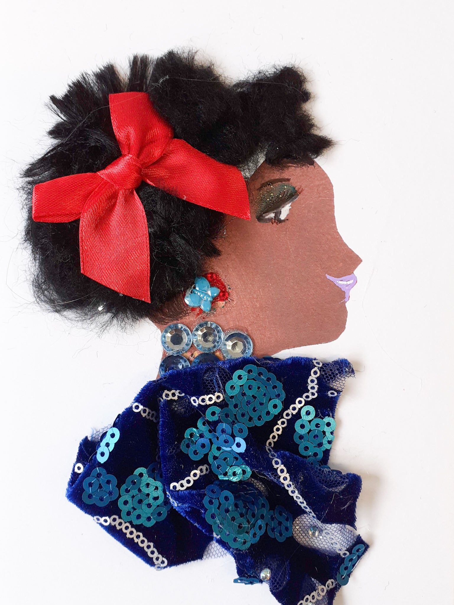 I designed this card of a woman named Doctor Jollof. She has a brown skin tone and is wearing a deep blue dress with a sparkling sapphire necklace matching her dress.