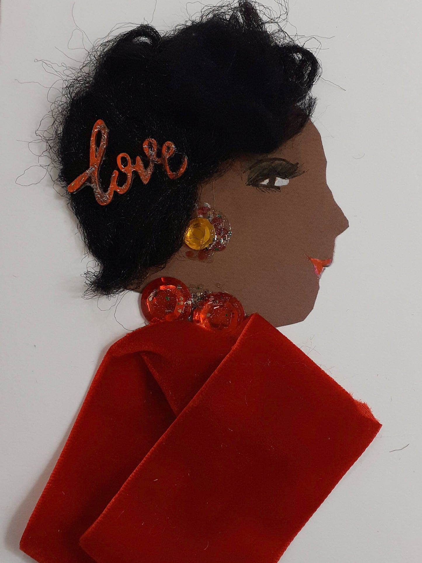 I designed this card of a woman named Victoria. Her skin tone is brown and she wears a red velvet dress, and a red necklace with two large gems. The word love in her short black hair.