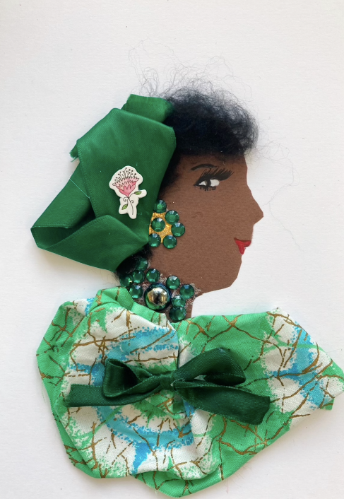 This card has been given the name Trisha. She wears a blue and green tye dye blouse with gold patterns over top. There is a forest green bow on the venter, and her headscarf matches. She wears green gem jewellery, and has a flower sticker in her hair.