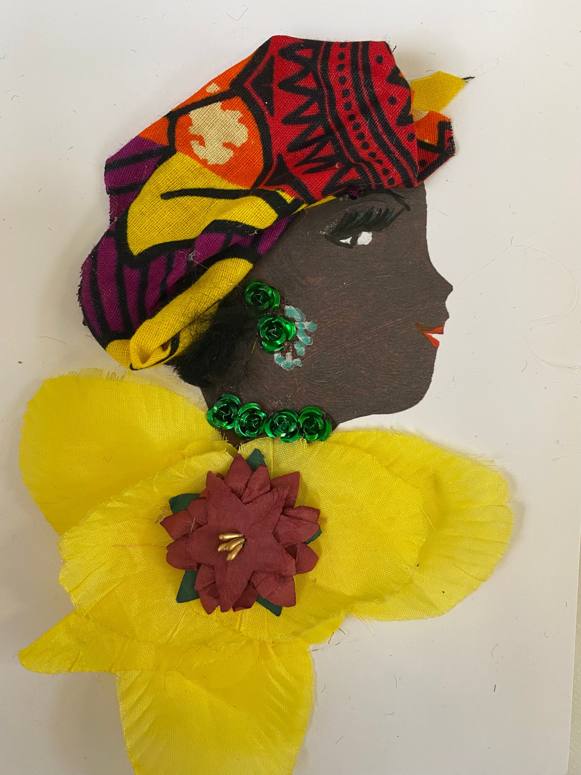 This handmade card called Dr. Yasmin Yellow. She has a black skin tone and is an artistic card featuring a vibrant woman in an eye-catching headwrap, a bright yellow blouse, and emerald green jewellery.