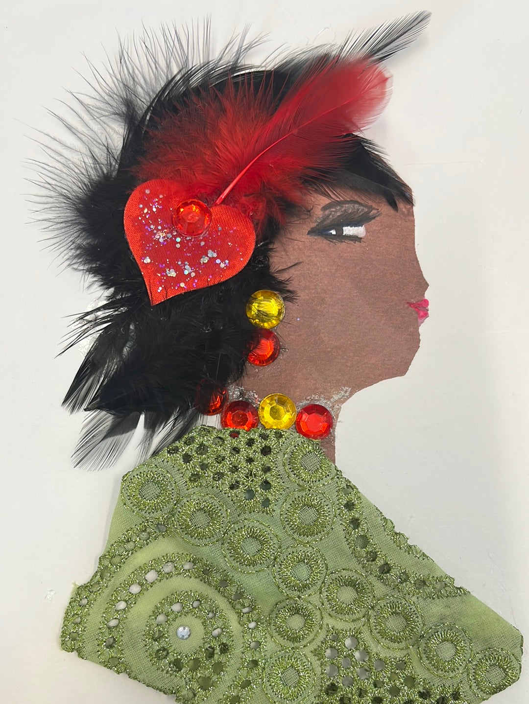 This card has been given the name Penny Pendleton. She wears a green eyelet blouse and a red heart with a feather in her black hair.