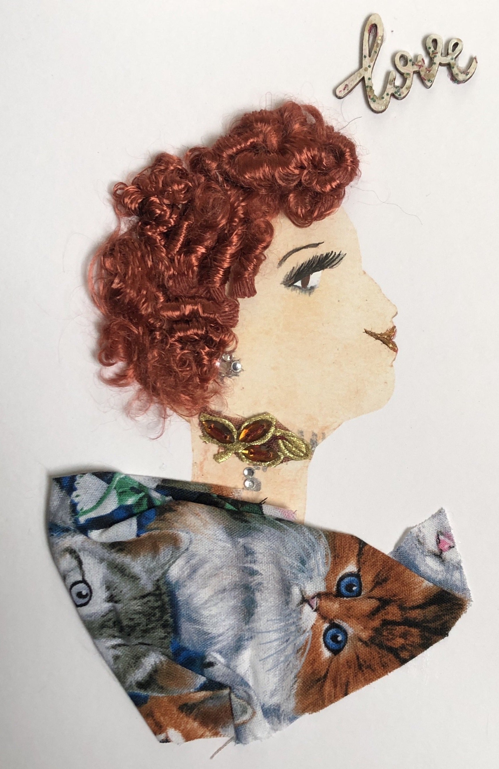 This card is of a woman given the name Catford. Catford wears a cat-patterned fabric, a small leafy necklace, and her hair is short, red, and curly. In the background of the card, there is a sticker in the top right corner which says "love"