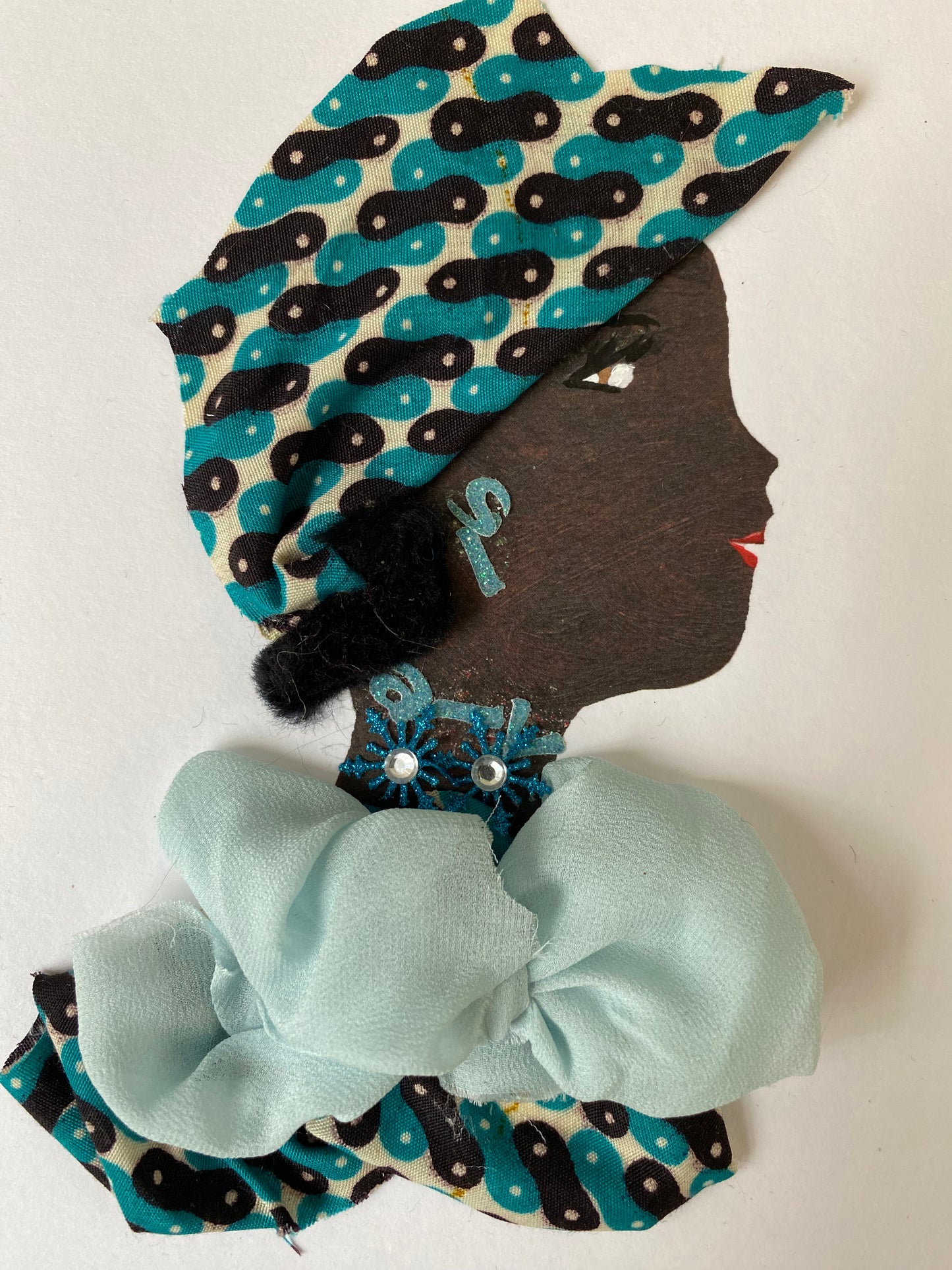 I designed this card of a woman named Tiffany Turquoise. She has a black skin tone and is wearing a stunning pattern hat. She wears a beautiful pattern blouse with a baby blue fabric. She wears a snow flake turquoise jewellery.