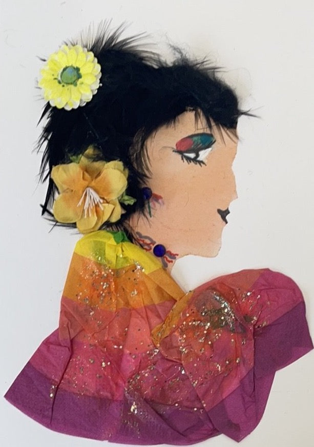 This card is named Lilly. She wears a rainbow paper blouse, and two yellow flowers in her short, black feathery hair.