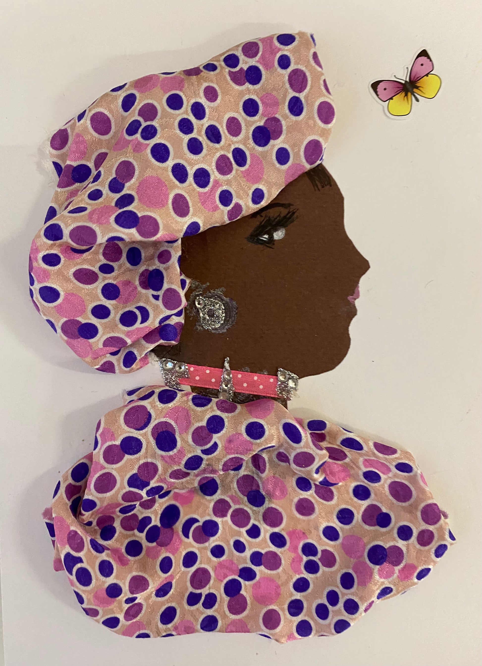 I designed this card of a woman named Orchid Rose. She wears a pink and blue polka dotted headwrap. She wears a matching blue and pink polka dotted blouse. She wears pink and silver jewellery. In the corner there is a pink and yellow butterfly.