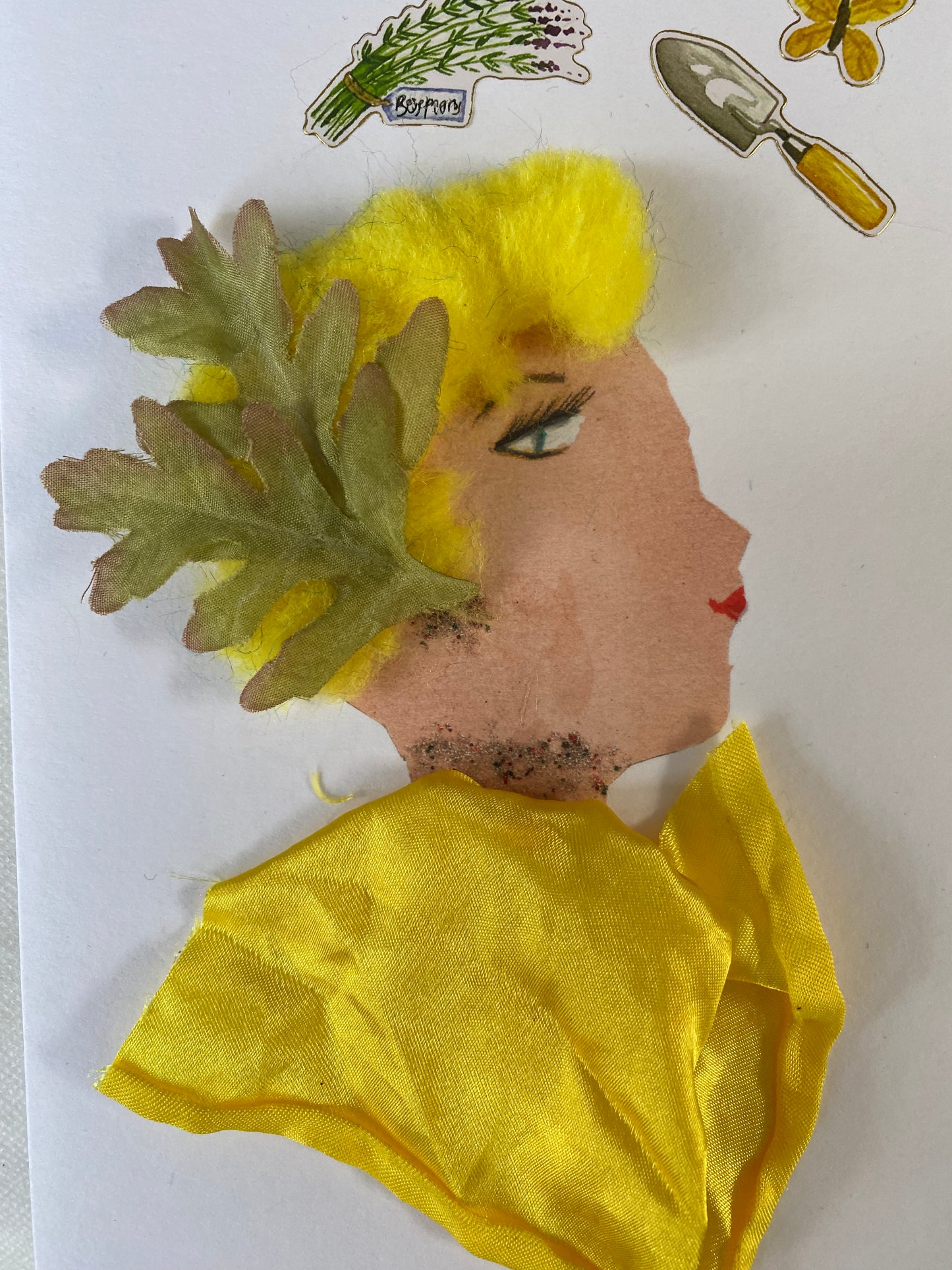 I designed this card of a woman named Yellow Pepper Garden. She has a white skin tone and is wearing a two beautiful green leafs in her hair. She wears a yellow silk blouse. She wears dazzling silver jewellery. In the top corner there is a gardening shovel, a bouquet of flowers, and a yellow butterfly. This hands finished card captures the joy and beauty of gardening, creating a moment of serenity and peace for the viewer.