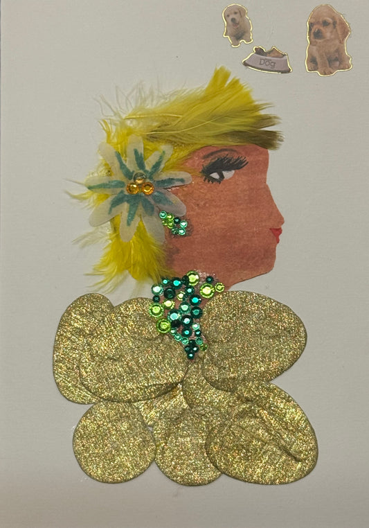 Handmade greeting card that doubles as a piece of art featuring a side-profile silhouette of a woman with a warm complexion. Her hair is styled with bright yellow feathers that fan outward, creating a soft, textured halo around her head, accented by a multicolored floral embellishment placed near her ear. She wears green gem jewellery for neckalce and earrings. Her top is glittery gold,  that is made up of circle shapes. Placed in the top right corner is three dog stickers above her head that add character.