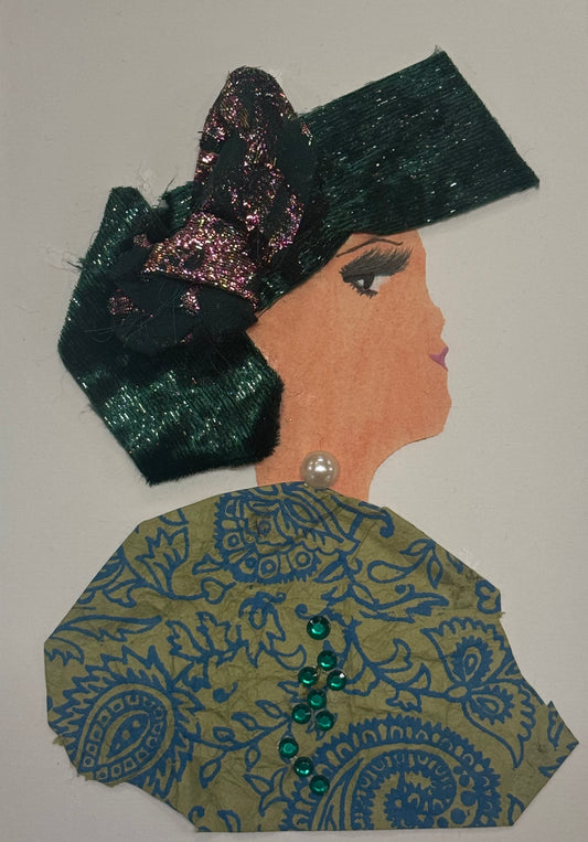 Handmade greeting card that can double as a piece of art, featuring a woman in profile wearing a large emerald green bow headpiece. She wears a patterned green, bold, and gold outfit with small green gems and a pearl detail. The design uses textured fabrics and decorative embellishments.