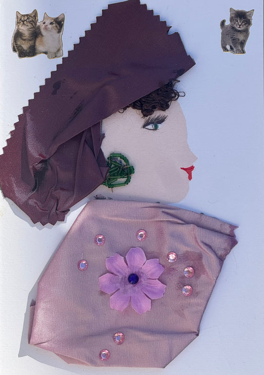 Handmade greeting card that can double as a piece of art featuring a profile collage of a woman with a dark purple headwrap and dark brown curly hair coming through the front of her forehead. She is also wearing a light purple blouse that features a purple flower in the center surrounded by pink circle gems. For her jewllery she is wearing bold green beaded earrings. Above her head are also two small cat stickers placed on each top corner of the card. 