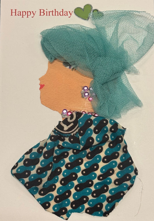 
Handmade greeting card that can double as a piece of art. A side-profile collage of a woman facing left, wearing a light teal mesh or netted fabric draped over her head and shoulders. Underneath, she has on a patterned outfit in shades of teal, black, and hints of white. Small, colorful gem-like accents are scattered near her face, adding pops of brightness. The overall look feels layered and slightly airy, with the mesh creating a soft, translucent effect over the stronger patterned base.