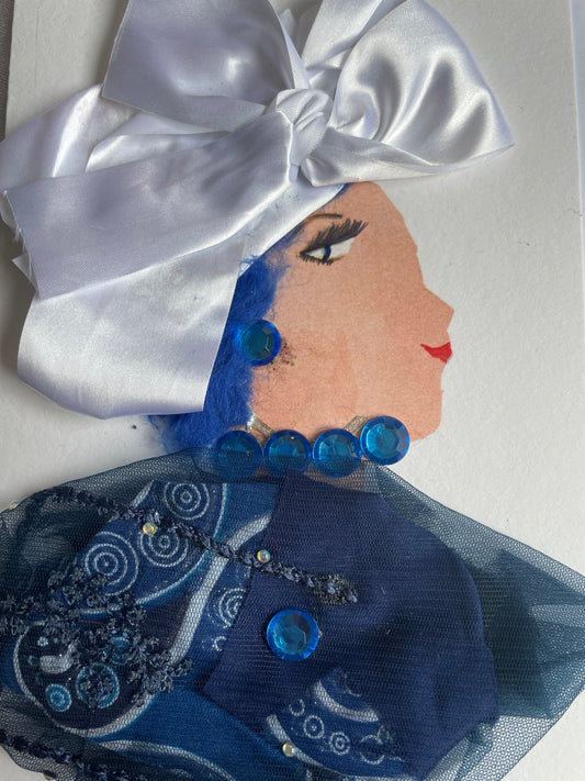 This card depicts a woman who wears a white hat. She wears a blue blouse that has blue jewellery attached. She wears a blue necklace and earrings. 